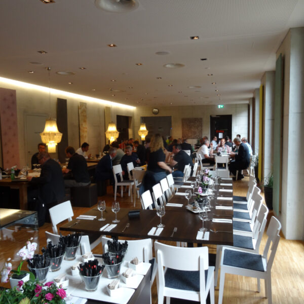 Gastraum mit Gästen an der langen Tafel